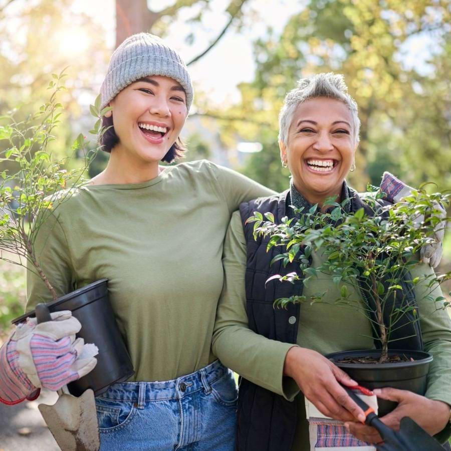 a couple of women holding plants